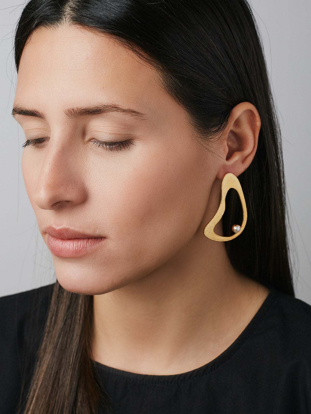 Model wearing Earrings with a Gold plated finish and white Pearls - Jouly K