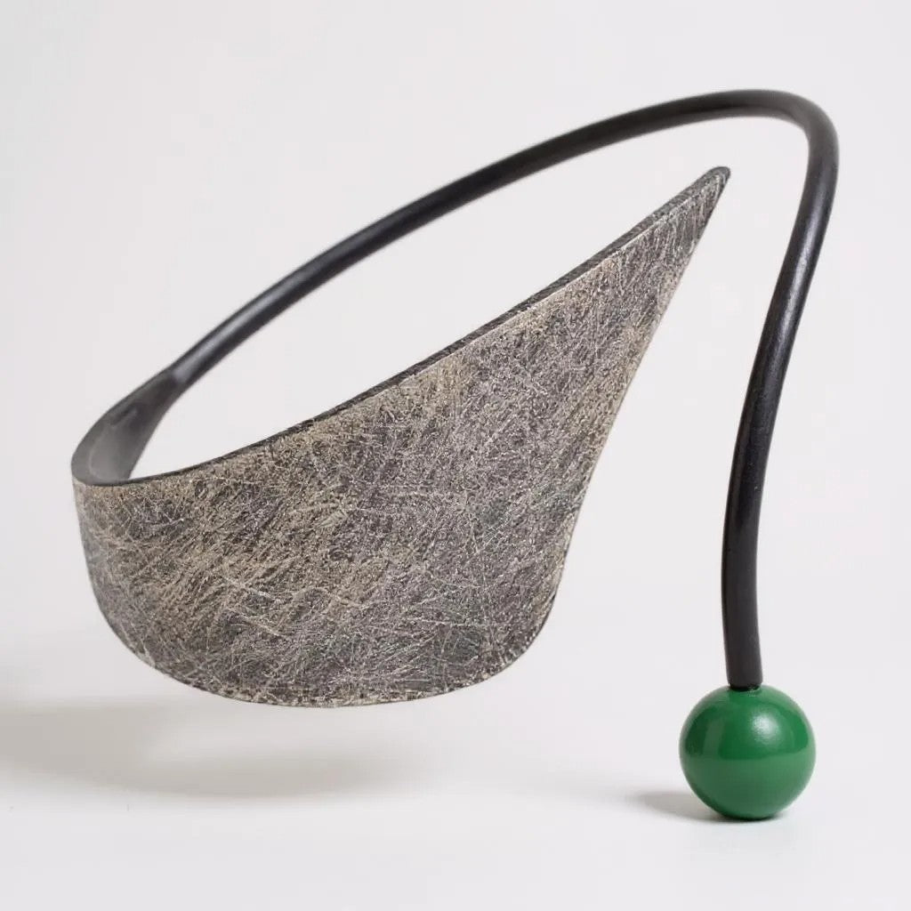 Modern necklace with a textured gray pendant and a green ball on a white background from Jouly K