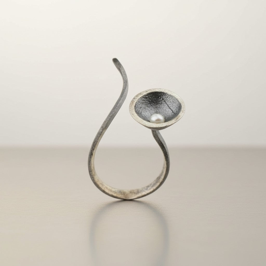 Silver ring with a textured design on a light gray background from Jouly K