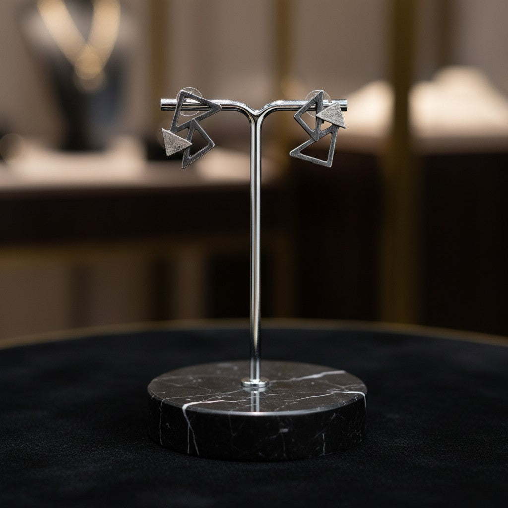 Jouly K Geometric abstract triangle earrings with a cool metallic finish. Interlocking triangles create a modern, minimalist silhouette.