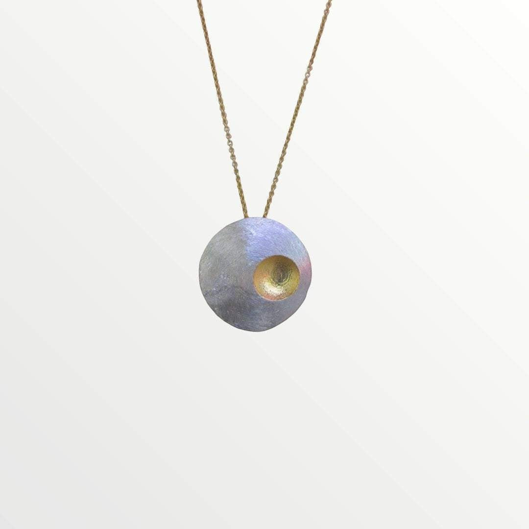 Jouly K handcrafted silver necklace with gold plated finish and oxidized texture. Features a round pendant with a central gold-toned opening.