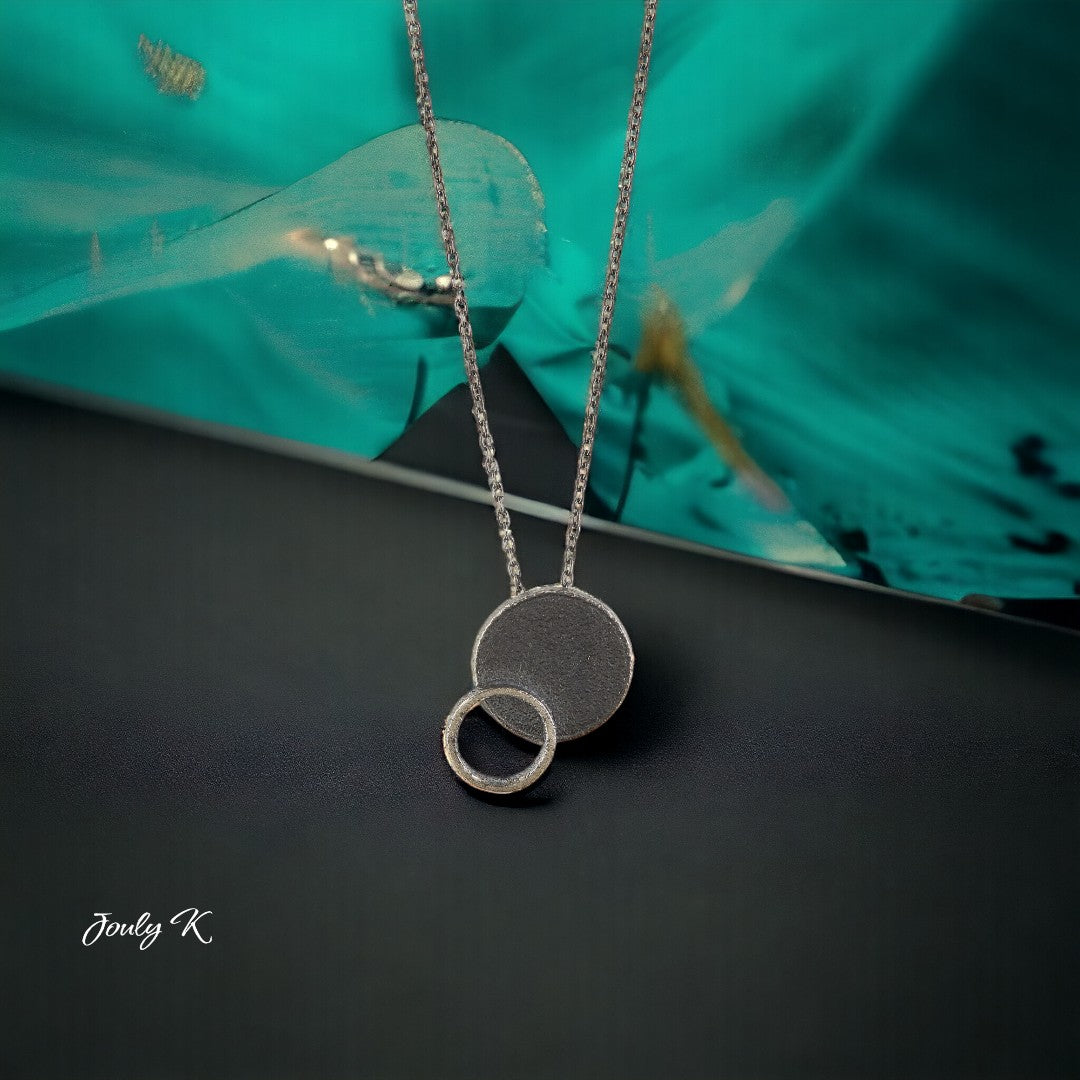 Jouly K silver necklace with oxidized finish, featuring two interlocking circles. Adjustable chain length 40-45cm.