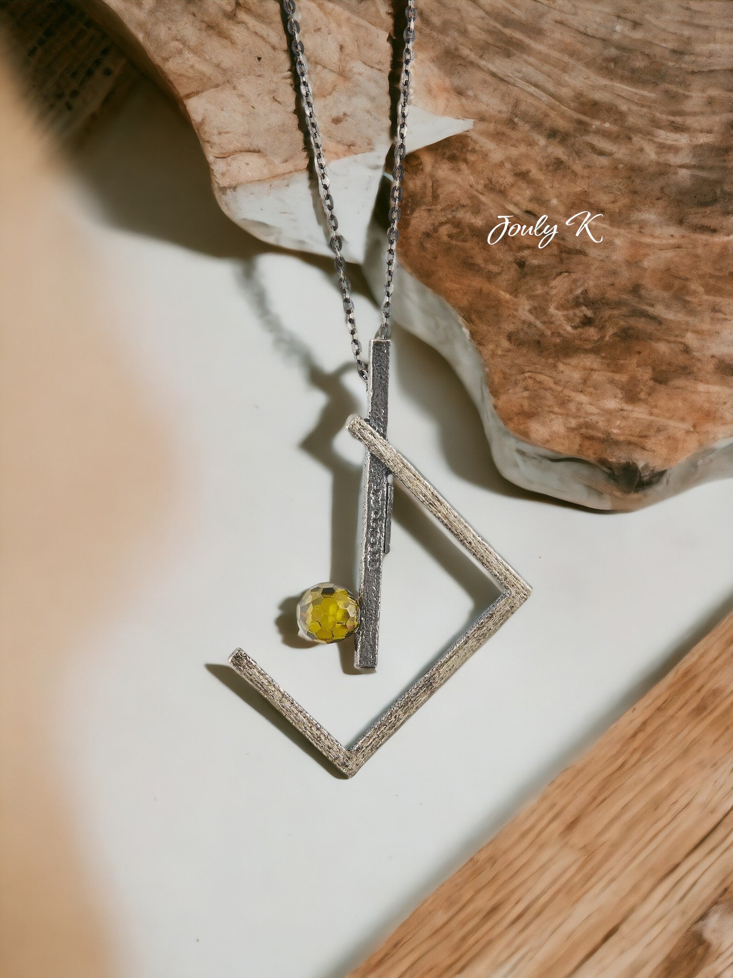 Jouly K handmade silver necklace with oxidized finish and a faceted green glass gem. Features a quirky geometric design.